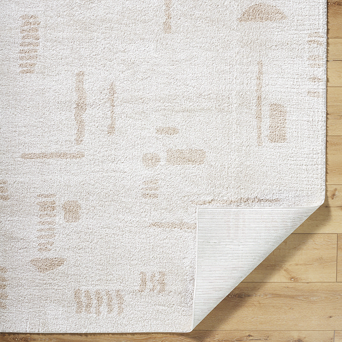 image of cream rug with beige abstract lines, corner folded over to reveal material underneath