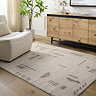 image of soft cream rug with light grey line patten, on light wood flooring of living room