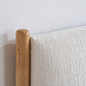 close up image on oak bedframe with linen headboard