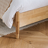 close up image on spindled feet and oak footboard of bed