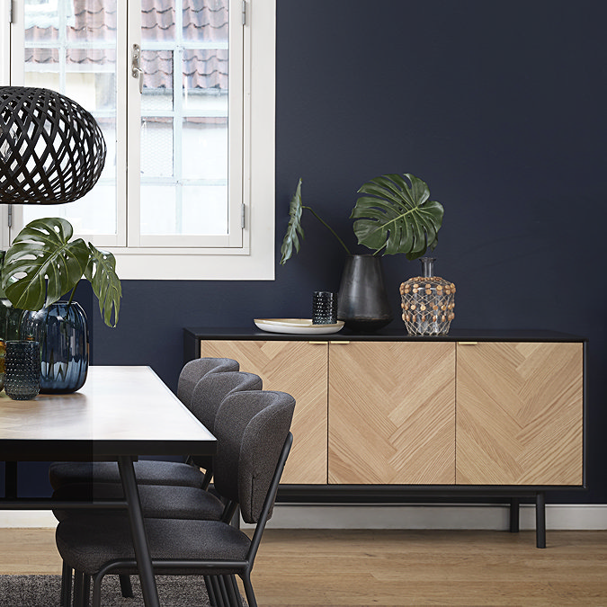 image of herringbone sideboard behind matching herringbone table, against teal coloured wall