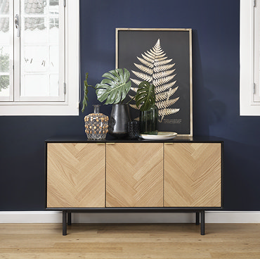 image of herringbone sideboard behind matching herringbone table, against teal coloured wall