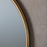 close up image of gold edge of round metal wall mounted mirror