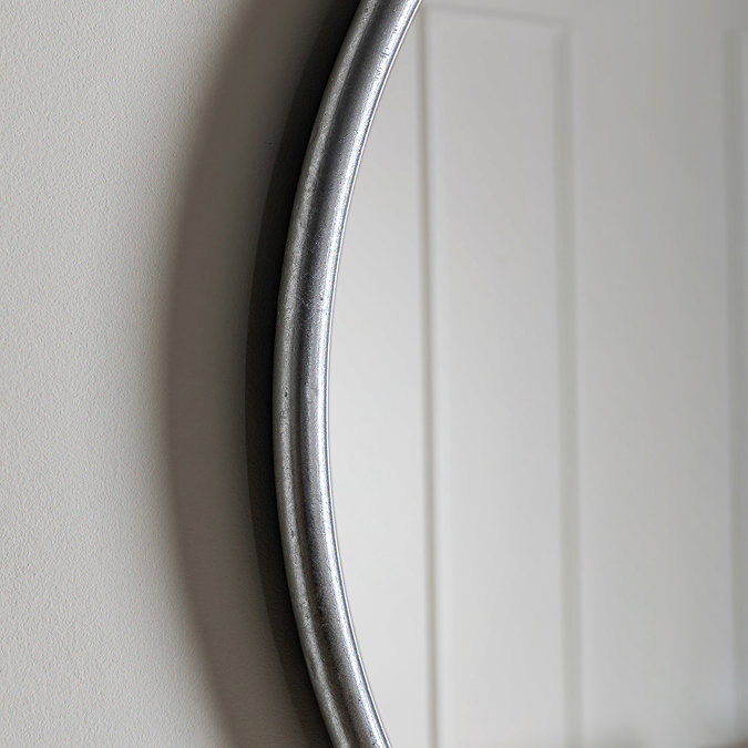 close up image of smooth rounded side of silver wall mounted mirror