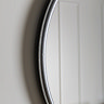 close up image of smooth rounded side of silver wall mounted mirror