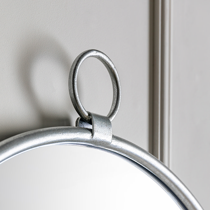close up image of decorative loop on top of soft silver iron wall mirror