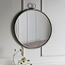 image of round soft silver mirror on cream panelled wall with decorative small loop on its top