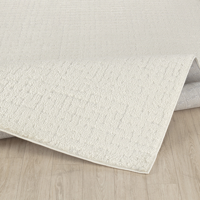 image of ivory distressed rug ruched up slightly to suggest its high pile