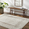 image of ivory rug with brown diamond pattern and border, on light wood flooring