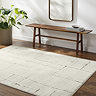 image of soft ivory rug with black scandi line design on dark wood flooring next to walnut bench and potted plant