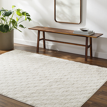image of soft ivory checkered rug folded slightly on light wood flooring