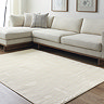 image of soft ivory geometric rug on light wood flooring in front of cream sofa