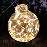 close up image of warm white glowing outdoor light, rounded shape and firefly glowing effect, in garden at night