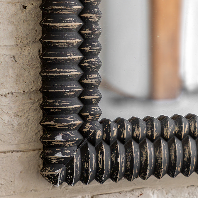 close up on bottom left corner of wooden blackwash mirror with textured surface