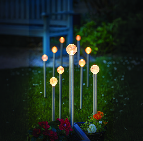 image of set of 10 small glow ball stake lights in garden at night