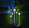 image of set of 10 small glow ball stake lights in garden at night