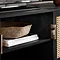 close up on shelving section of tv unit, with books and woven storage basket inside