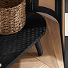 close up image of curved edge of rattan tv unit, door slightly open to reveal wicker basket inside, and light reflecting through rattan door on to black shelf