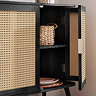 close up image of right side sideboard door open to show storage space inside, with wicker basket on upper shelf and plates on the lower