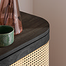 close up image on smooth curved edge of top of black rattan sideboard