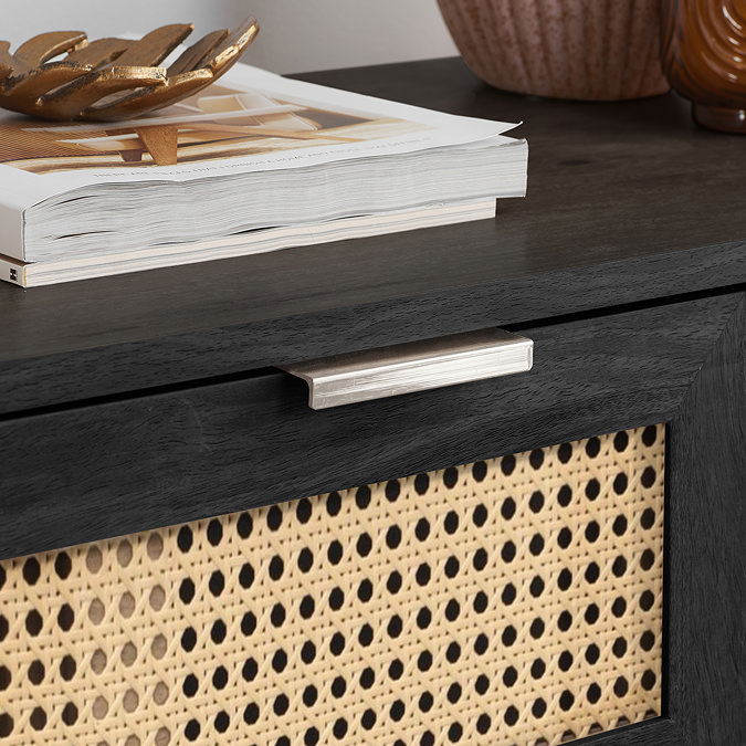 close up image of rattan design of chest of drawers with black frame and gold handles