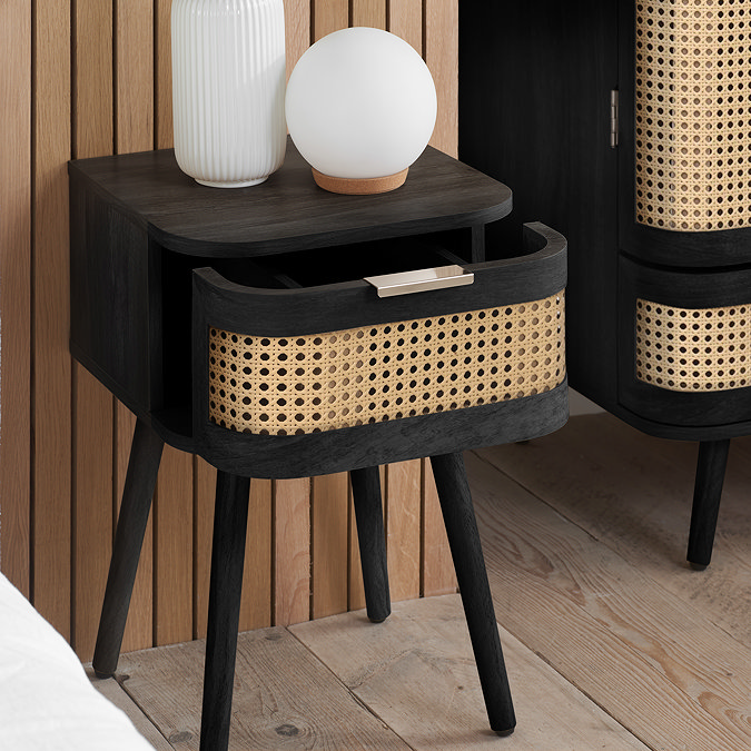 close up angled image of black side table with rattan drawer, with drawer slightly open