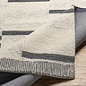 image of cream rug with lines, folded over to show the material underneath