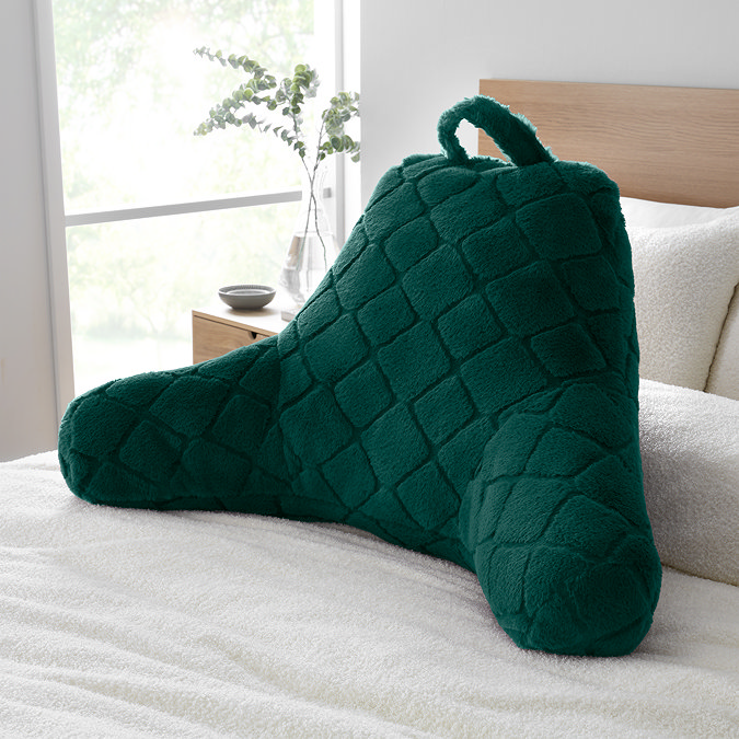 cosy diamond cuddle cushion in bottle green on bed image 1