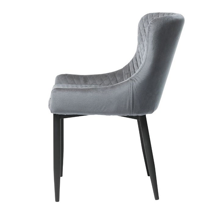 side on image cut out on white background of grey velvet harlequin stitched dining chair with black legs