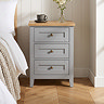 close up image of three drawer bedside table in grey with oak top