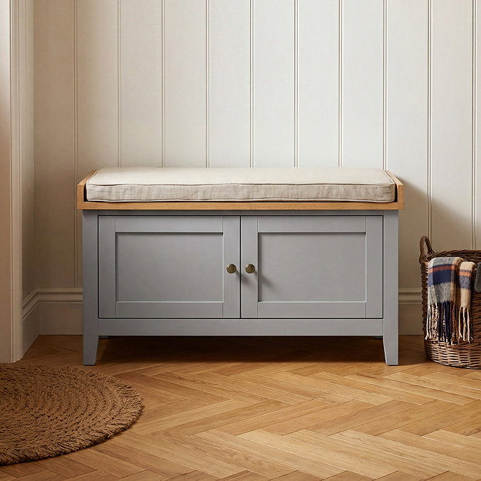 close up image of grey bench with two doors and cushioned top