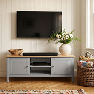 image of painted grey tv unit in living room with tv over it and vase on the oak top