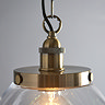 close up image on antique brass fixture of large clear glass pendant light