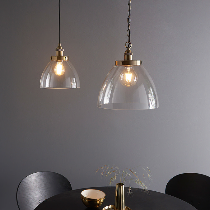 image of large and smaller pendant light with clear glass shade, housing warm LED filament bulbs