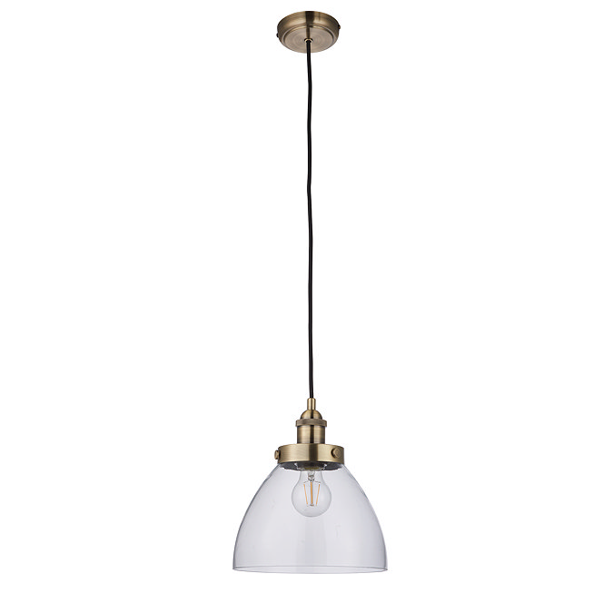 image cut out on white background of pendant light with clear glass shade and antique brass fixture