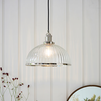 image of ribbed glass pendant light shade with nickel knurled detail, hanging in front of cream panelled wall