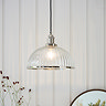 image of ribbed glass pendant light shade with nickel knurled detail, hanging in front of cream panelled wall