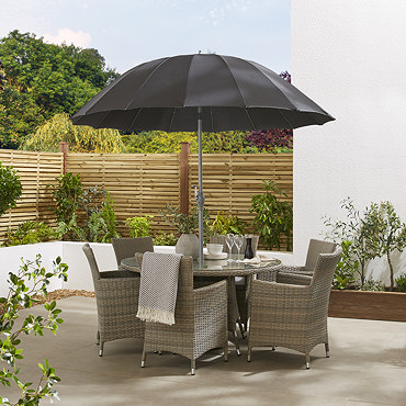 image of black parasol in table with light grey rattan chairs, on sunny patio, slightly tilted to show adjustable pole and shade