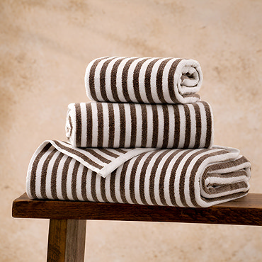 image cut out on white background of folded stripe chocolate brown towel