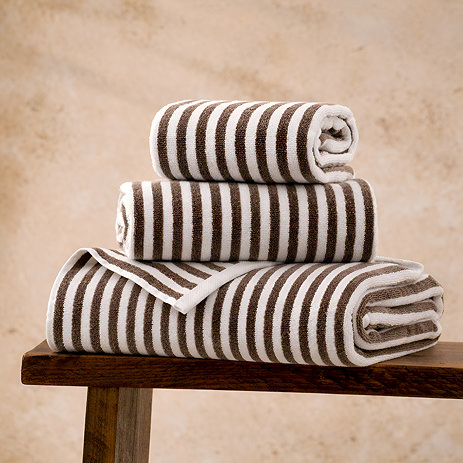 image of chocolate brown stripe towel pile on wooden bench