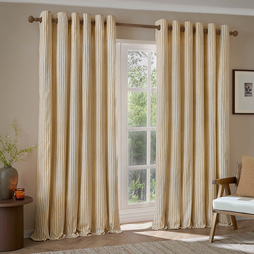 Hebden Striped Blackout Eyelet curtains in honey yellow over a window close up image