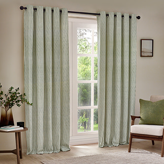 hebden striped eyelet curtains, open over a large living room window with cream chair in the right hand corner.