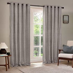 striped grey eyelet curtains hung, open, in front of a living room window