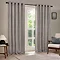 striped grey eyelet curtains hung, open, in front of a living room window