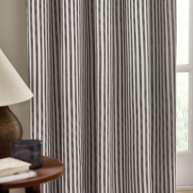 close up on middle part of left striped grey curtain, highlighting the elegant drape and pattern