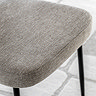 close up on natural fabric of dining chair with black metal legs