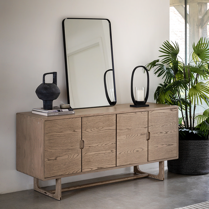 image of four door smoked oak sideboard in dining room with mirror atop it