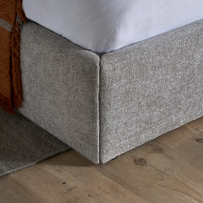 close up on grey fabric of bottom of bed