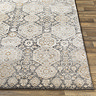 close up image of corner of brown rug with oriental pattern on wood flooring