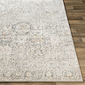 close up image of front of vintage rug with grey pattern laid flat on wood flooring